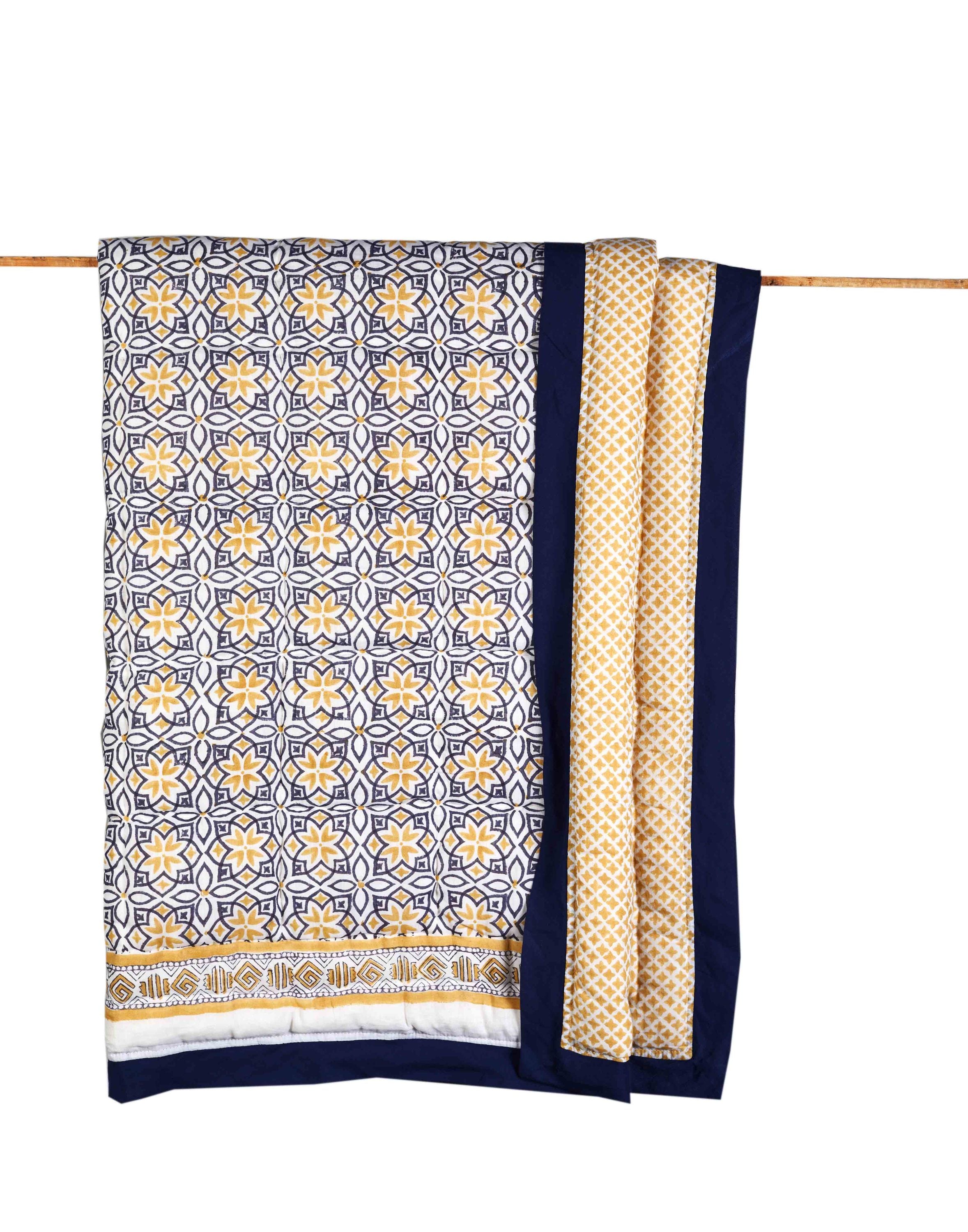 An Ivory Meleager SEMINYAK BLUE COTTON QUILT hanging on a clothes line.
