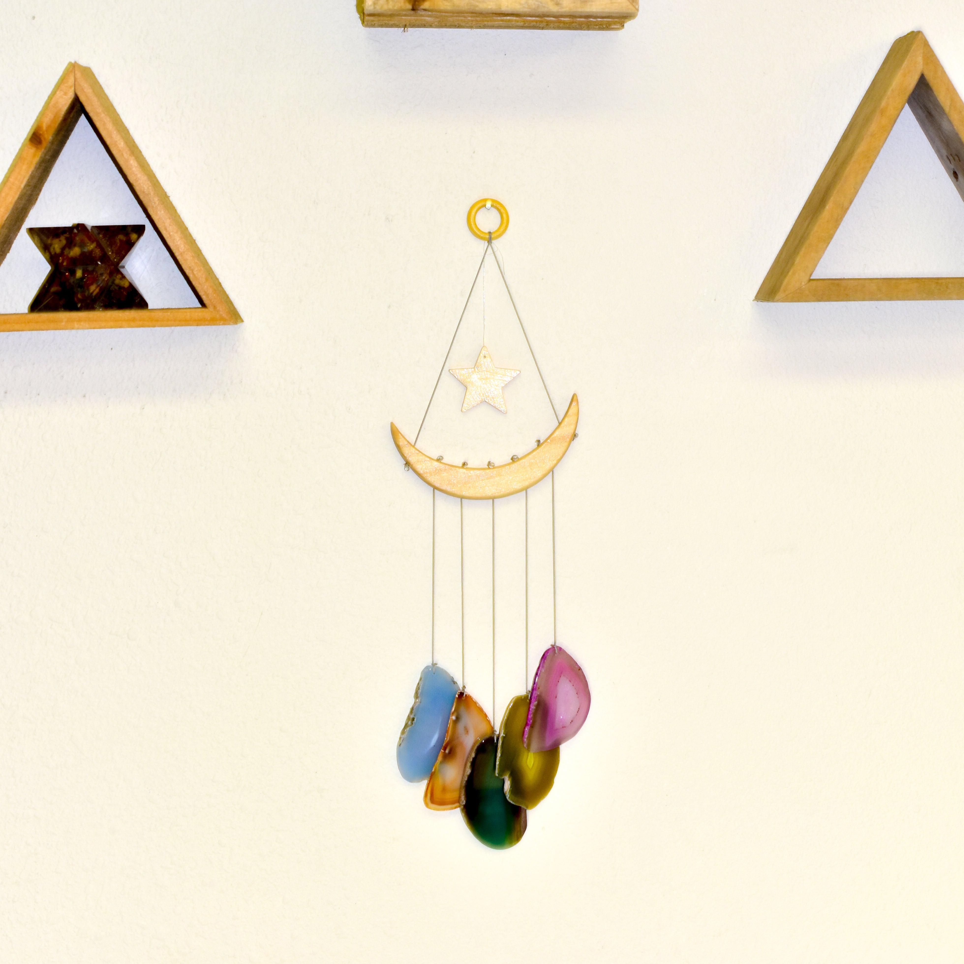 The NEW Star & Crescent Moon Agate Wind Chime features a mesmerizing wood crescent moon embellished with vibrant stones that mimic natural agate slices, all elegantly accentuated by two wooden triangular shelves.