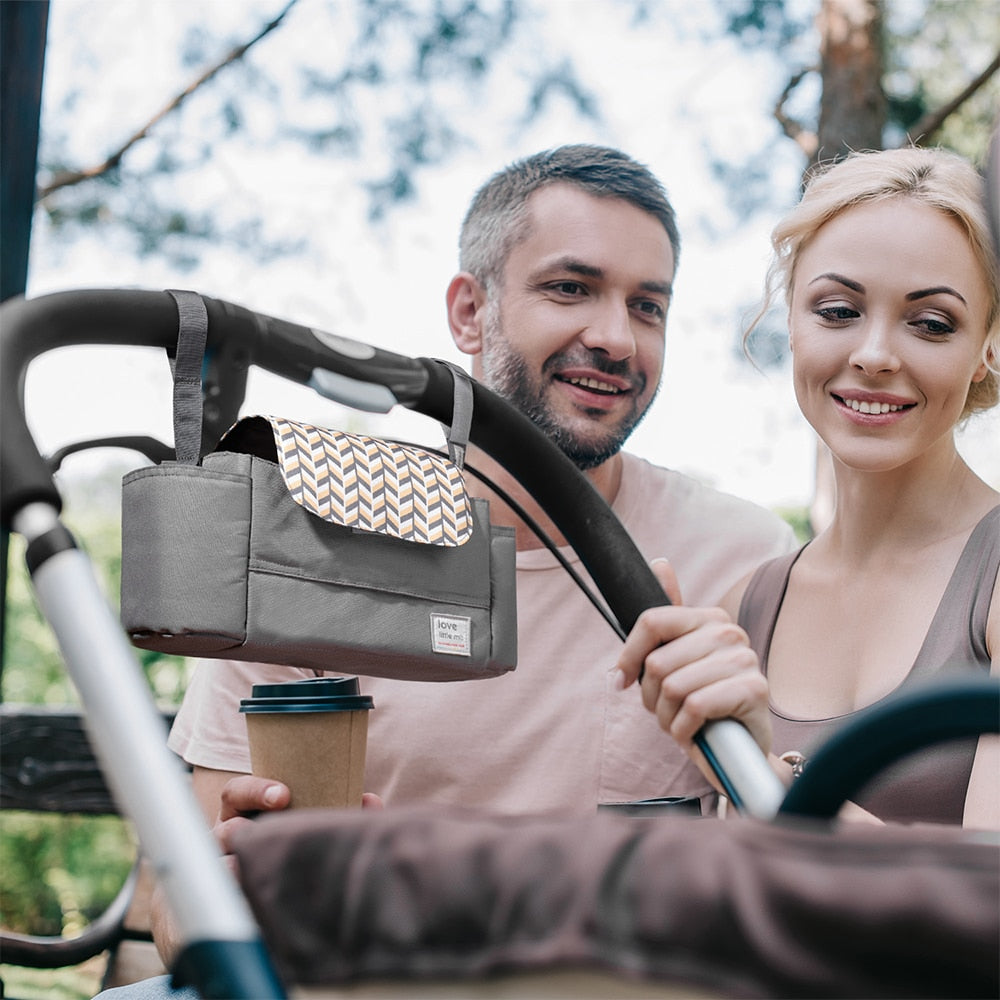 A man and woman with a baby in a High Capacity Stroller Organizer.