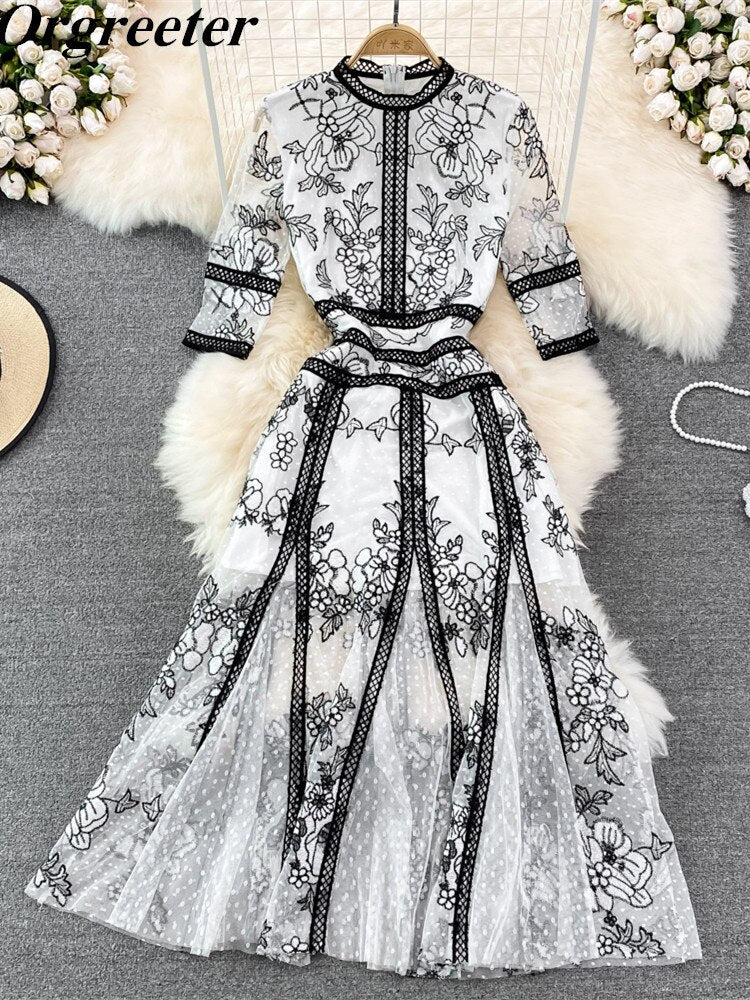 An High Quality Embroidery Mesh Long Dress For Women Vintage Lace Hollow with floral patterns, black trim, and a waist ribbon displayed on a mannequin against a vintage lace background.