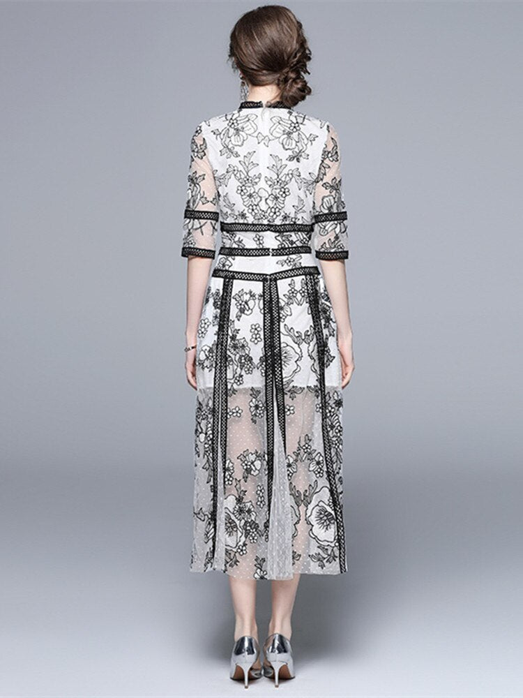 An High Quality Embroidery Mesh Long Dress For Women Vintage Lace Hollow with floral patterns, black trim, and a waist ribbon displayed on a mannequin against a vintage lace background.