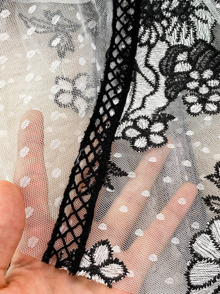An High Quality Embroidery Mesh Long Dress For Women Vintage Lace Hollow with floral patterns, black trim, and a waist ribbon displayed on a mannequin against a vintage lace background.