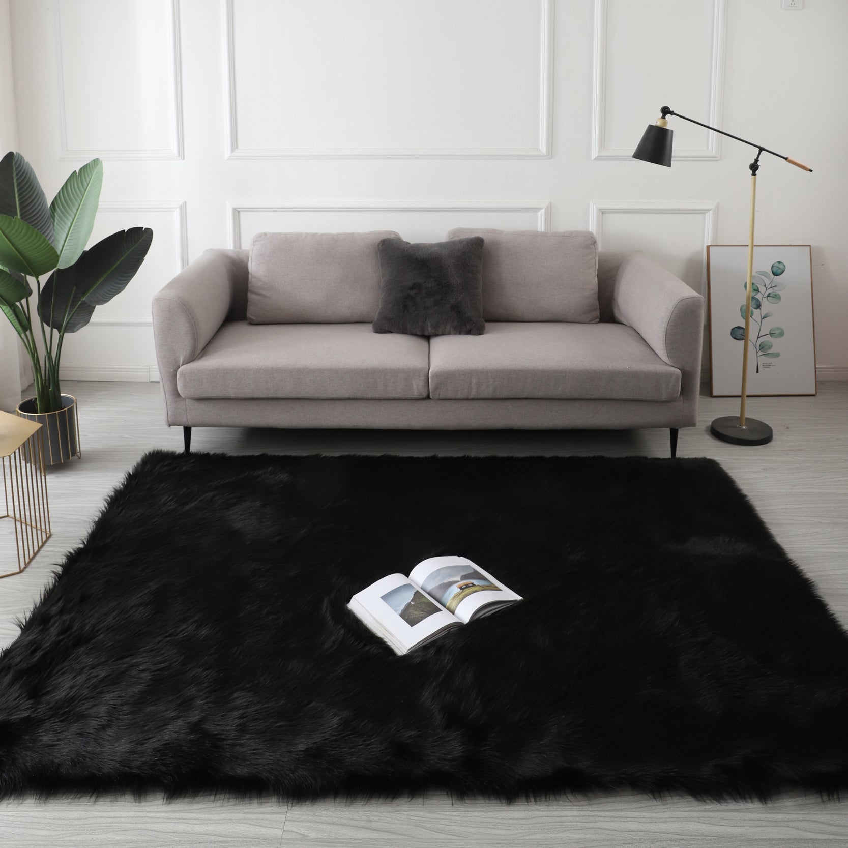 A modern living room featuring a large, Cozy Ultra Soft Fluffy Faux Fur Black Area Rug with an open book on it, a tan sofa, and a side table with a potted plant, against a backdrop of sheer