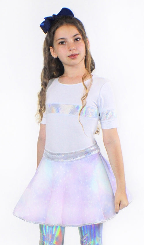 A young girl wearing a white t-shirt and a Sky Blue Beech Lana Galaxy holographic skirt.