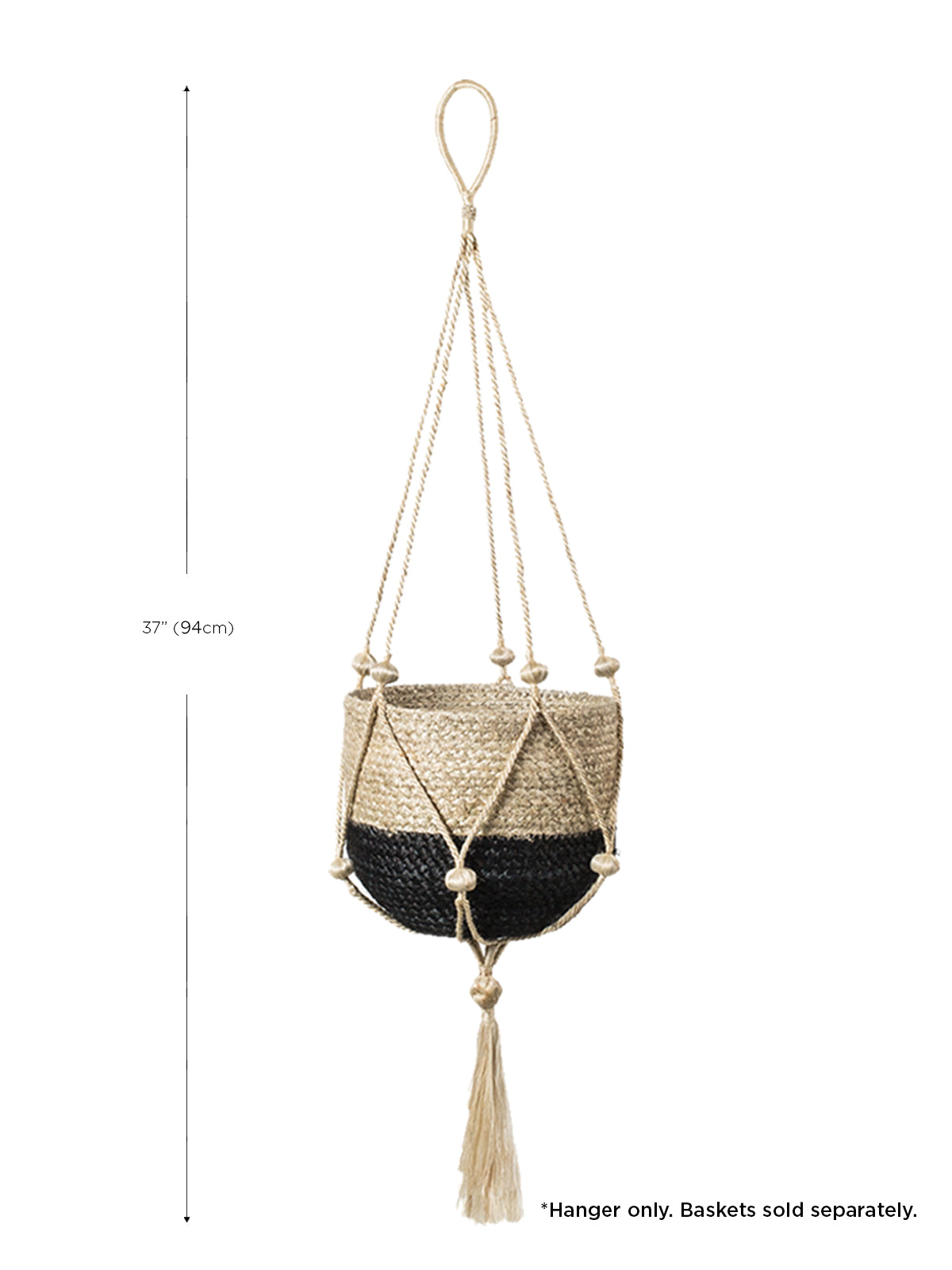 The Plant Hanger - Nadu features a woven basket with a black and natural fiber design, suspended by a handmade jute hanger adorned with braided and knotted ropes, complete with a tassel at the bottom.