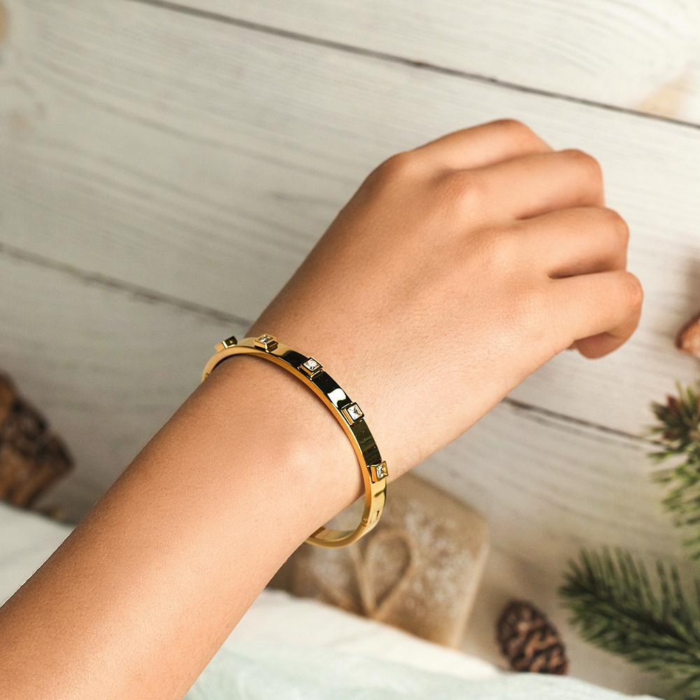 The Metal Stone Hinged Bangle is a sleek 14K gold PVD plated stainless steel bracelet, featuring square diamond accents evenly spaced along its hypoallergenic band.