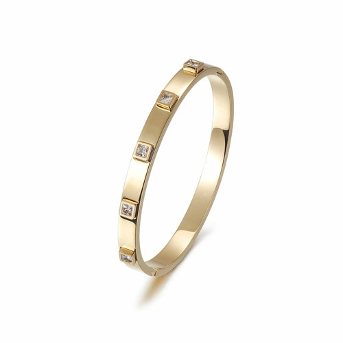 The Metal Stone Hinged Bangle is a sleek 14K gold PVD plated stainless steel bracelet, featuring square diamond accents evenly spaced along its hypoallergenic band.