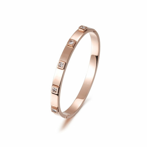 The Metal Stone Hinged Bangle is a sleek 14K gold PVD plated stainless steel bracelet, featuring square diamond accents evenly spaced along its hypoallergenic band.