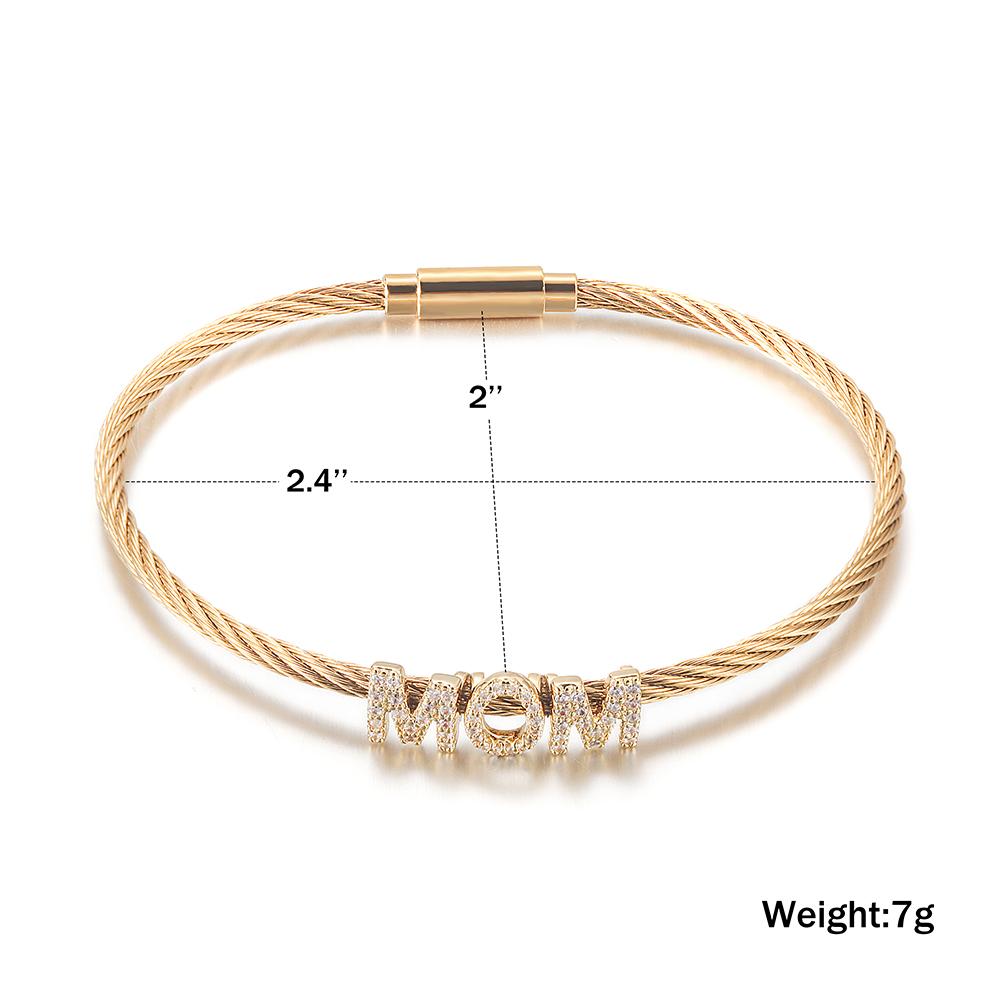 The "Mom" Pavé Bracelet displays "MOM" with diamond-studded letters on a cable chain, crafted from hypoallergenic 14K gold PVD plated material for enduring beauty and comfort.