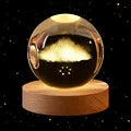 Displaying a brand new solar system design, two 60cm 3D Crystal Ball Glass Balls with warm night lights sit atop wooden bases, accompanied by a small astronaut figure.