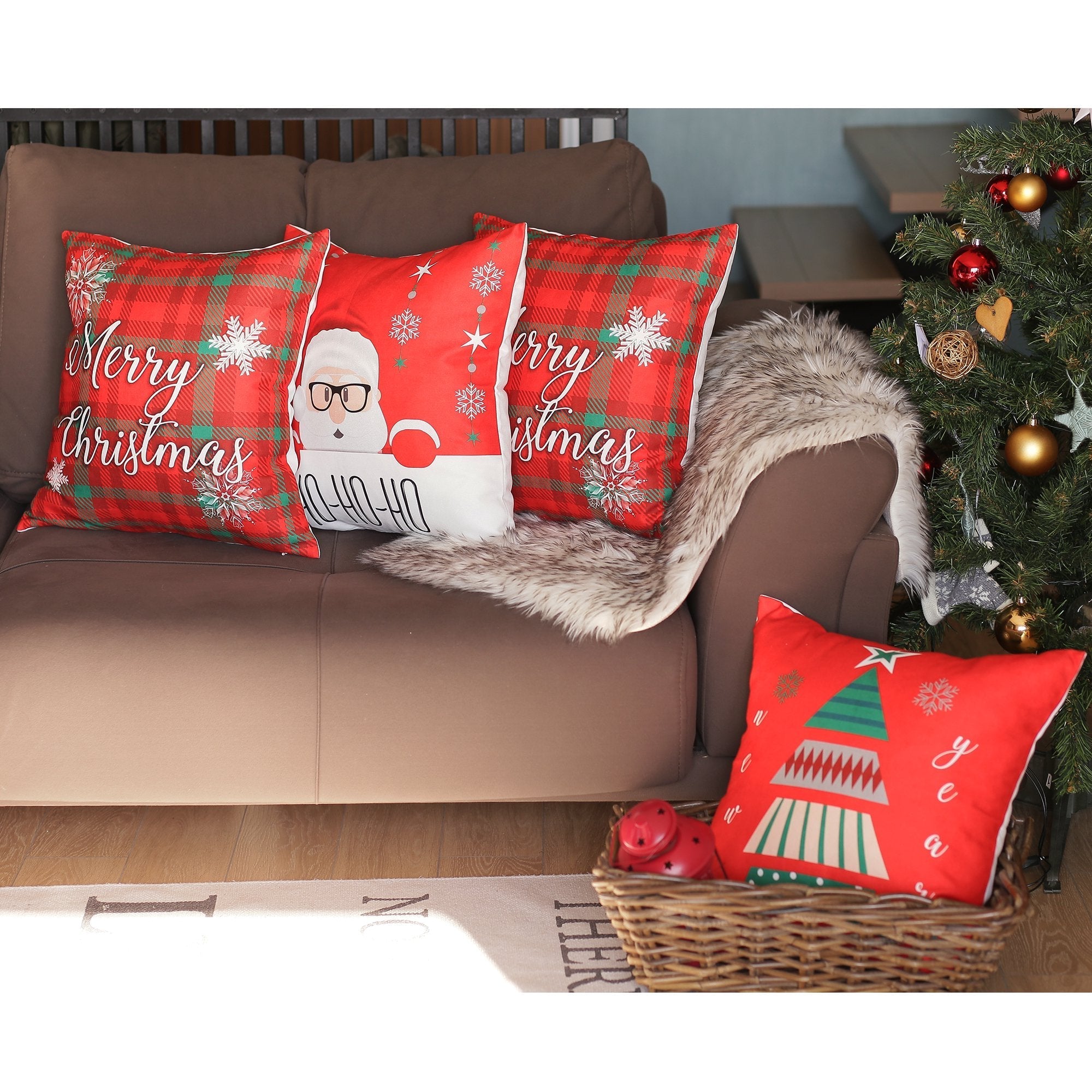 A set of four charming Christmas-themed decorative throw pillows, each measuring 18" x 18" in white and red, adorns the sofa alongside a festive Christmas tree and a wicker basket with an additional pillow. These pillows enhance the holiday decor while meeting the safety and quality standards of OEKO-TEX Standard 100.