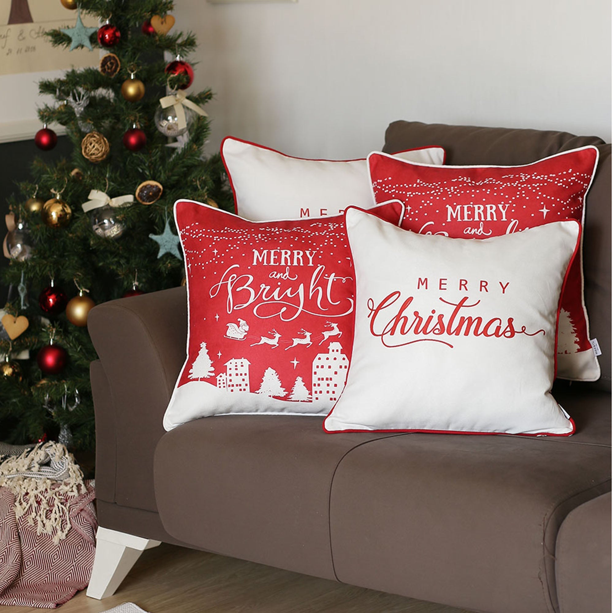 Arranged on a brown sofa near a Christmas tree are four Decorative Merry Christmas Throw Pillow Covers, each measuring 18" x 18", in white and red. These pillow covers boast luxurious brushed fabric with "Merry Christmas" and "Merry and Bright" text, featuring OEKO-TEX Standard 100 certified materials.