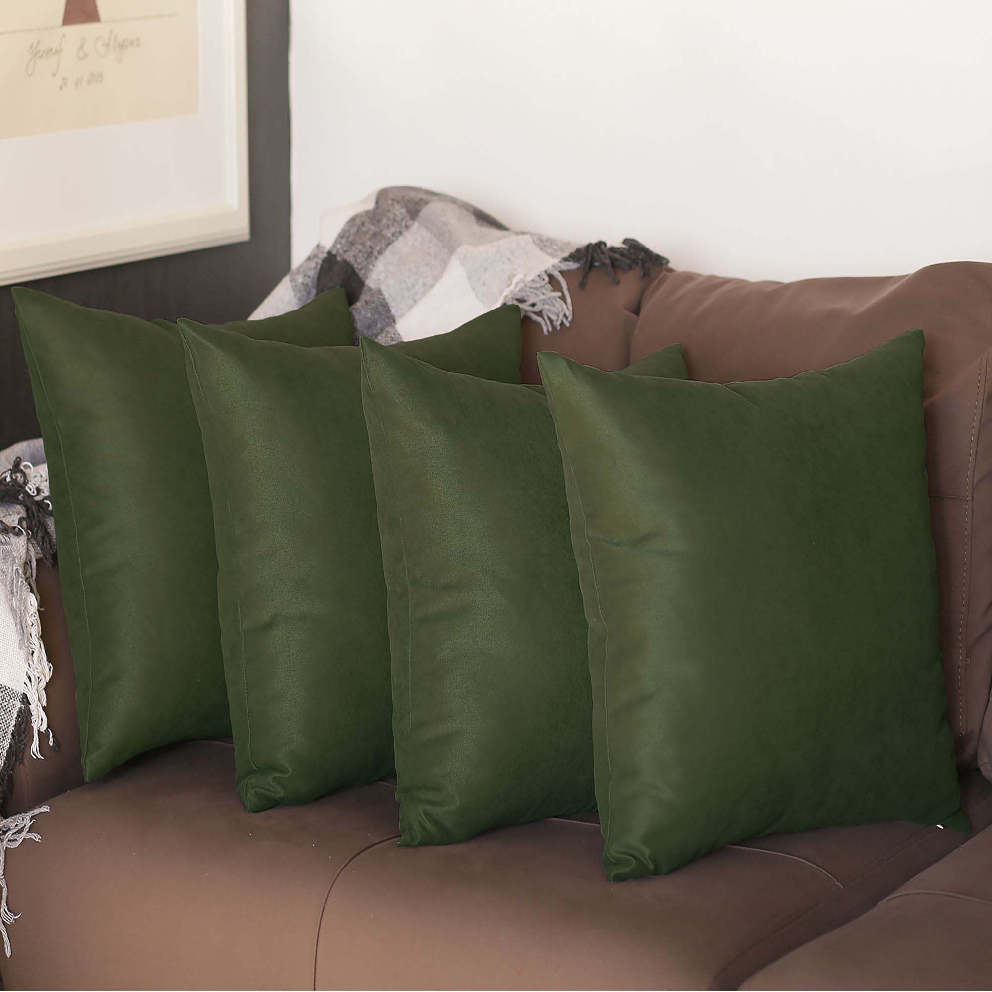 Four pillows from the Honey Set of 4 Decorative Throw Pillow Cover Solid Color Pillowcase collection are artfully arranged on a brown couch, complemented by a patterned throw blanket in the background.