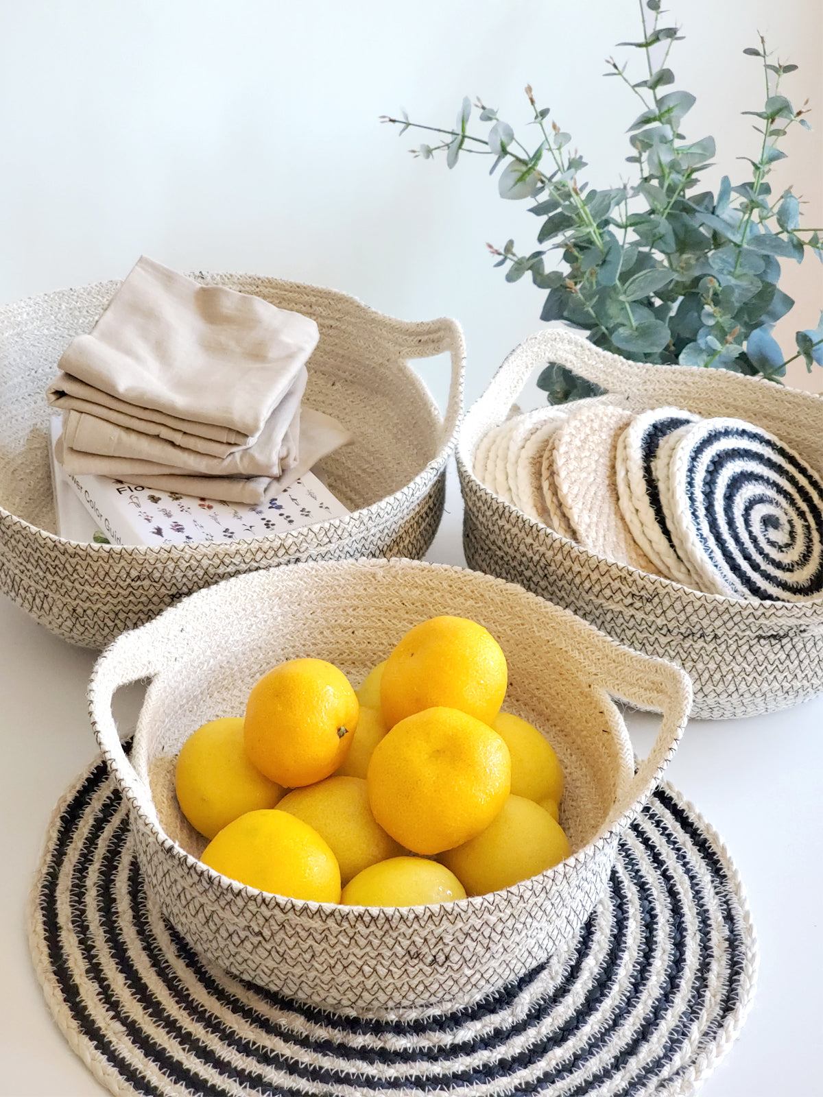 Three Amari Fruit Bowls in black are elegantly arranged on a white background. Handcrafted by Fair Trade artisans, these sustainably made pieces add an eco-friendly touch to any space.