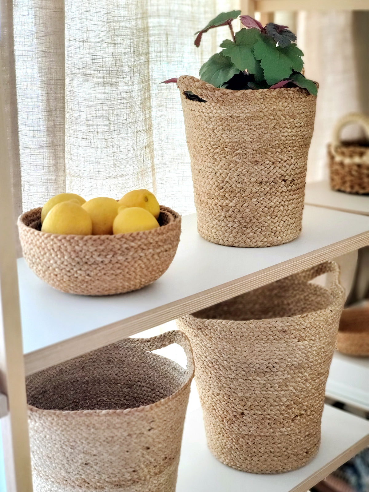 The Kata Basket with Slit Handle, crafted by Fair Trade artisans, is a set of three handwoven pieces that feature varying sizes and are elegantly displayed against a white background.