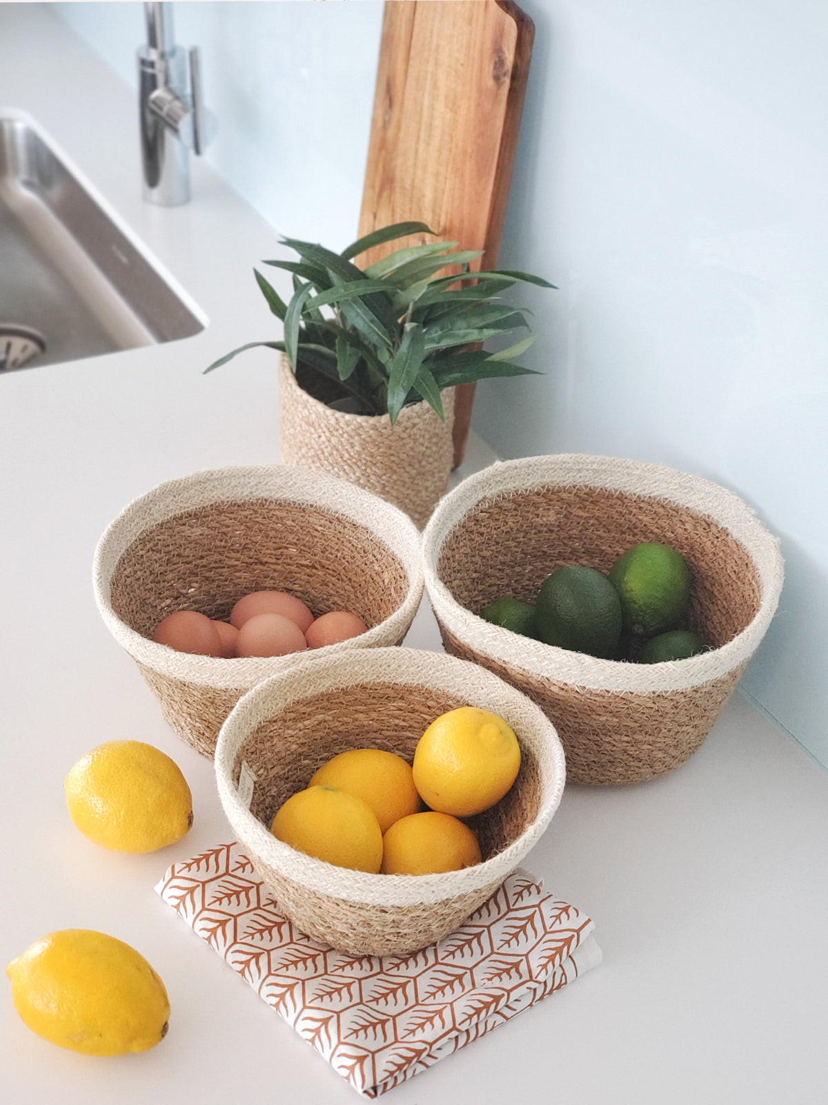 The Savar Plant Bowl Set, featuring three woven bowls of different sizes crafted by Fair Trade artisans, is arranged against a plain background.