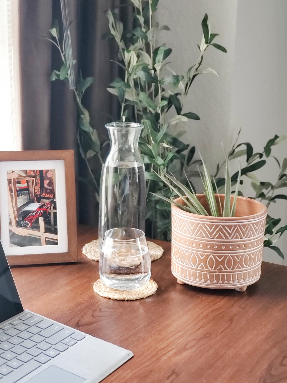 The Hand Etched Terracotta Pot - Small, featuring intricate artisan-inspired white patterns, stands elegantly against a plain background.