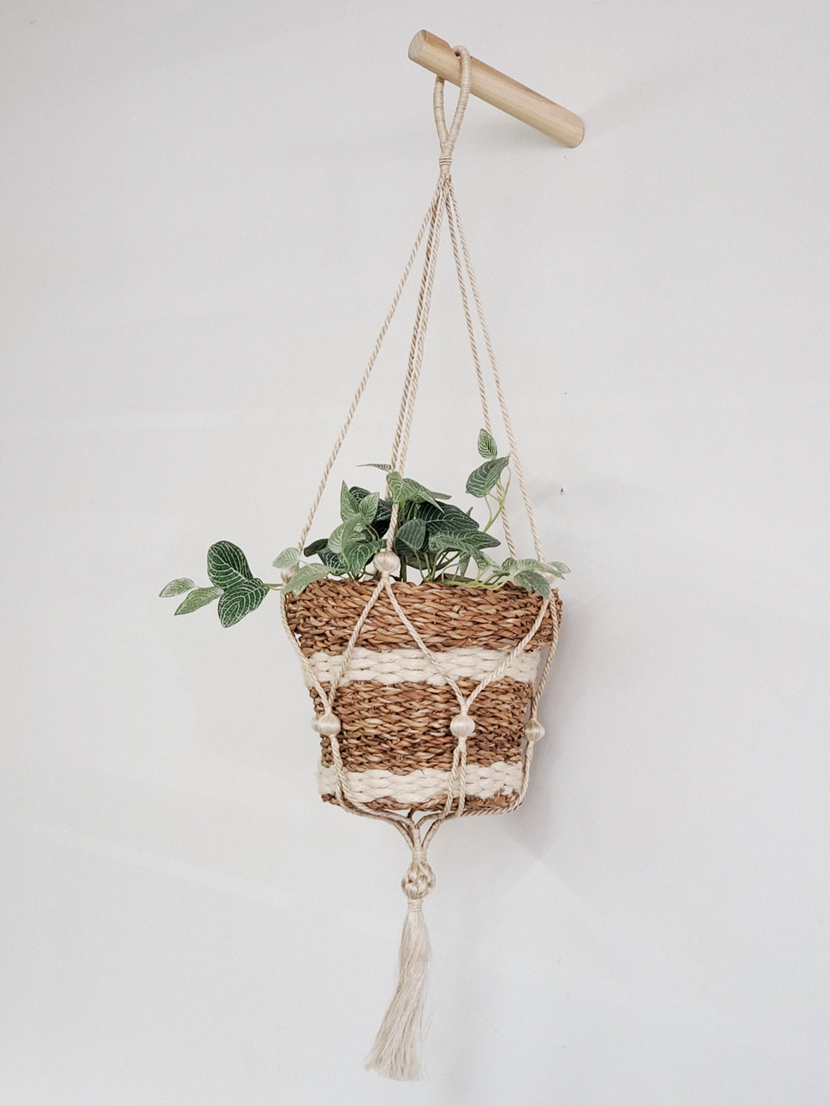 Three Savar Nesting Plant Baskets, crafted by Fair Trade artisans, feature white stripe accents. Two are stacked upright while one lies sideways on a plain background, showcasing their sustainable beauty.