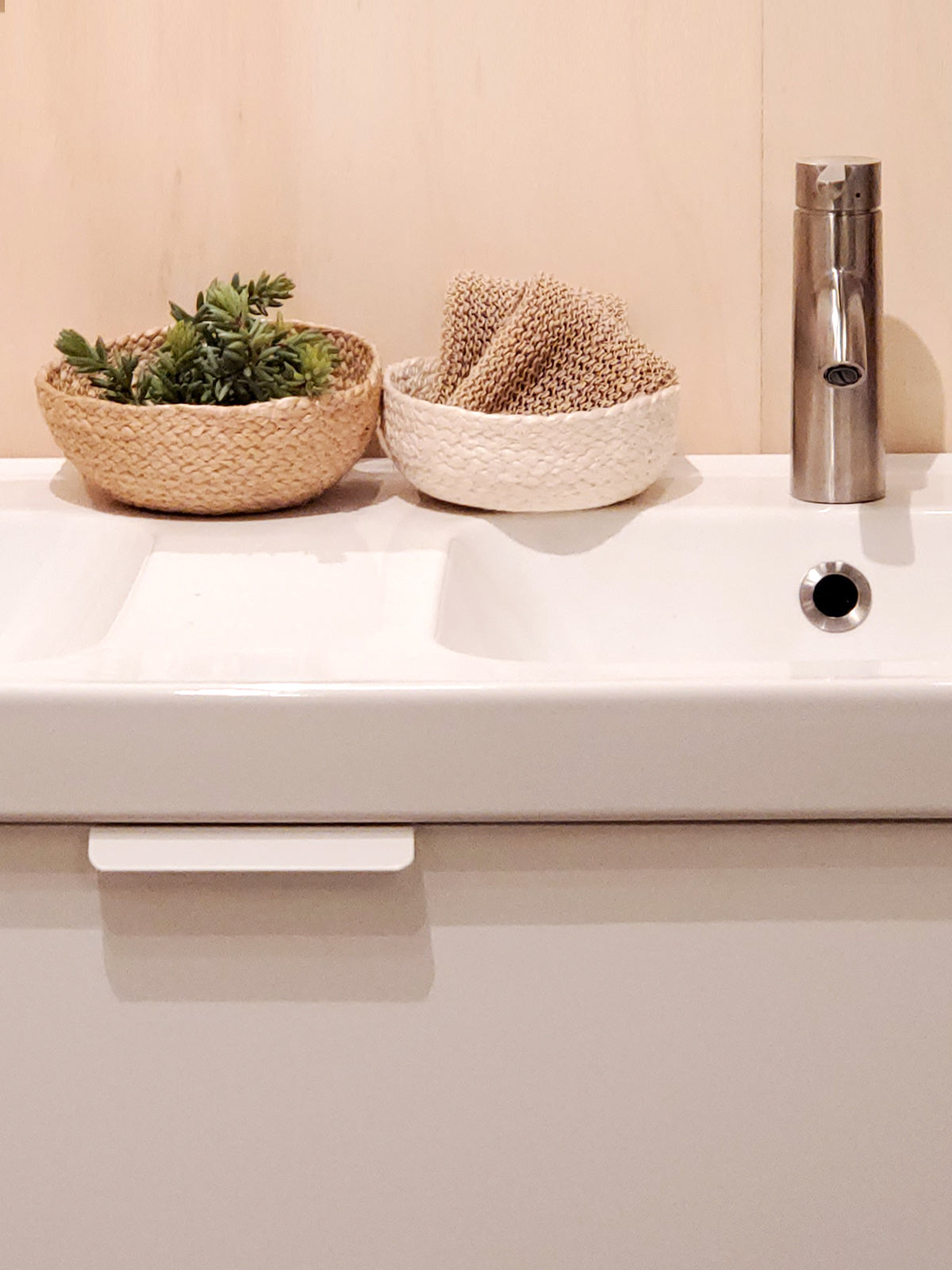 On a flat surface against a plain background, a set of four Kata Candy Bowls in white, crafted by fair trade artisans, is displayed. These versatile woven straw baskets highlight the beauty and authenticity of natural jute.