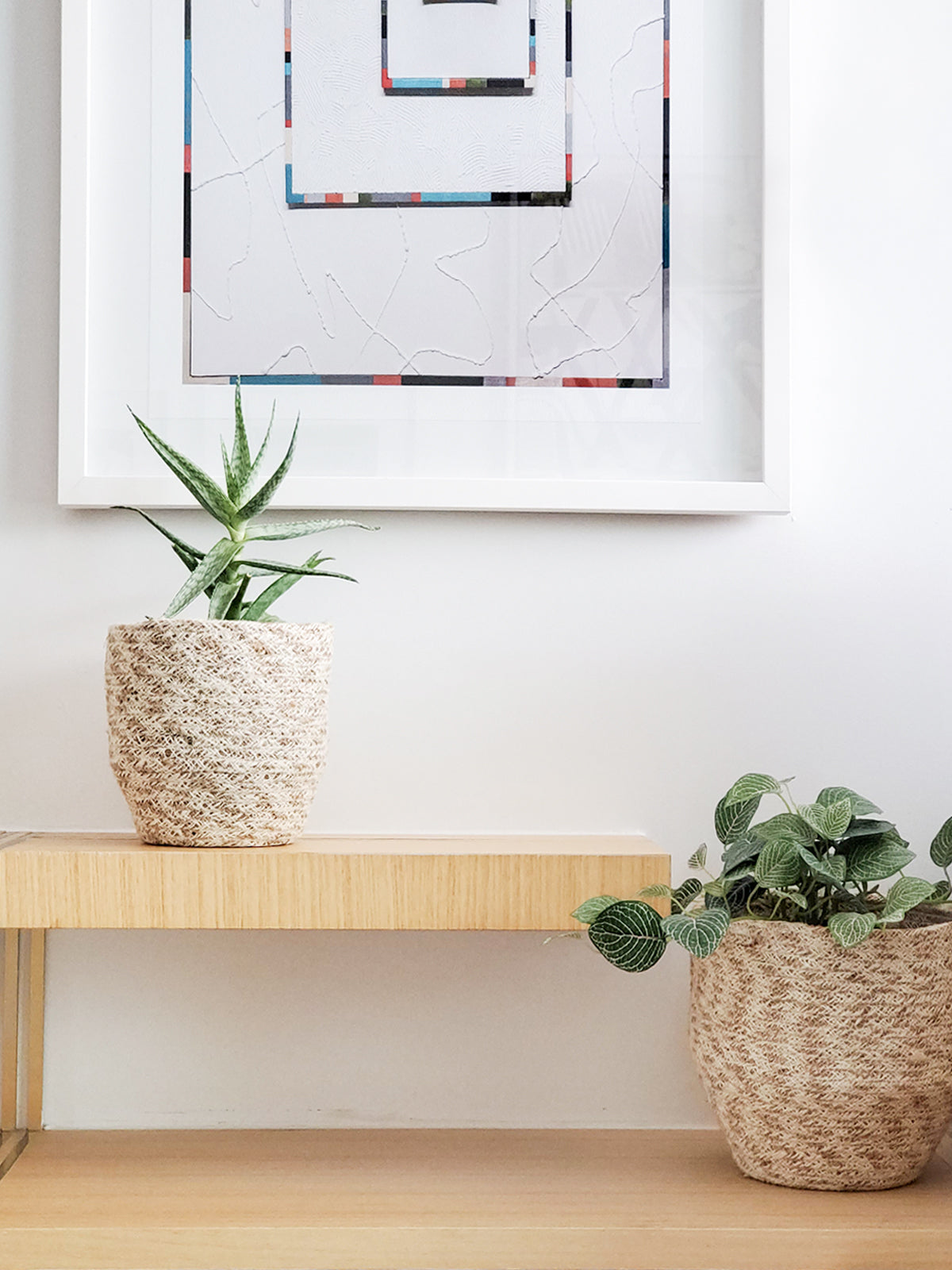 Two Agora Bins, handcrafted woven baskets of varying sizes, made with Fair Trade Jute Yarn, are placed side by side against a plain background.