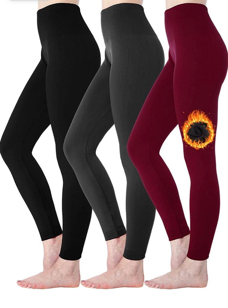 Two women wearing the 2 Pack Women’s Fleece Lined Leggings High Waist Stretchy Warm, one in black featuring a flaming design on the knee and the other in maroon. Both are shown from mid-thigh to feet, highlighting their stylish winter leggings that are perfect for cold days.