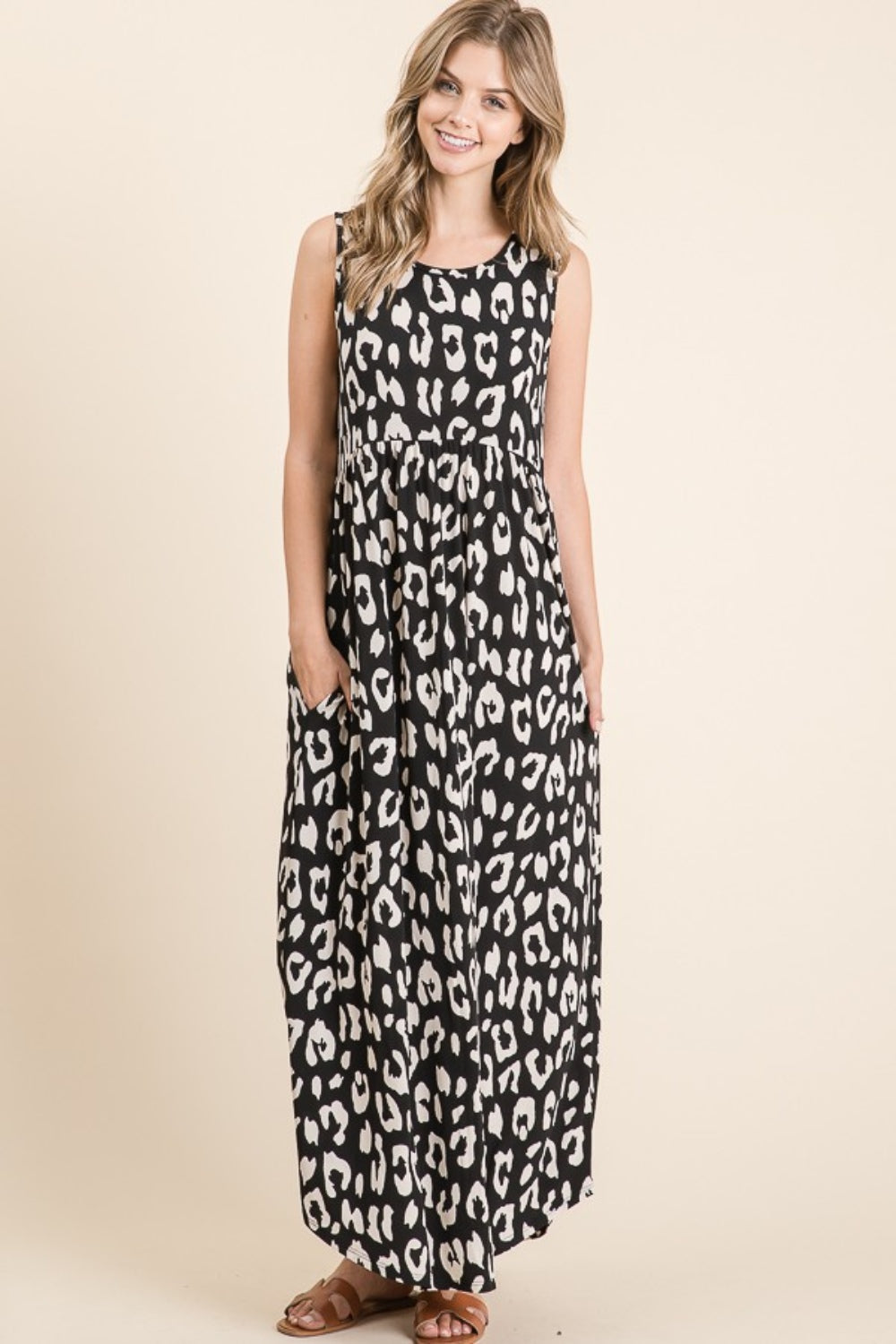 A person wearing the BOMBOM Leopard Maxi Dress with Pockets, paired with brown sandals, is standing against a beige background.