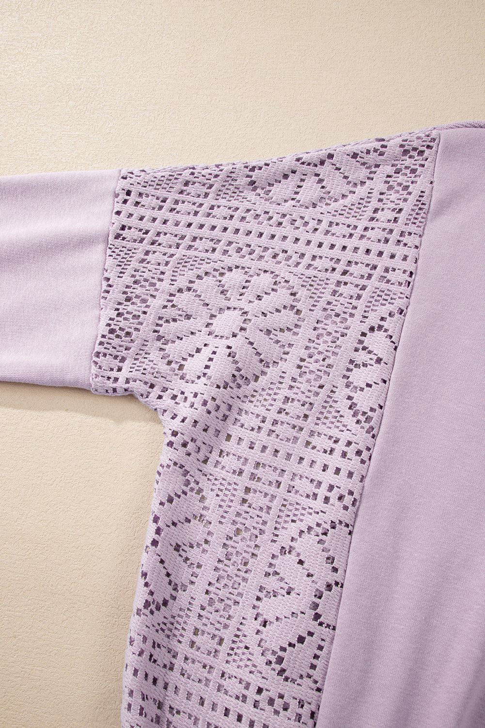 A person with long hair is seen from the back wearing the Orchid Petal Knit Crochet Exposed Seam Ribbed Trim Sweatshirt, blue jeans, and a brown crossbody bag.