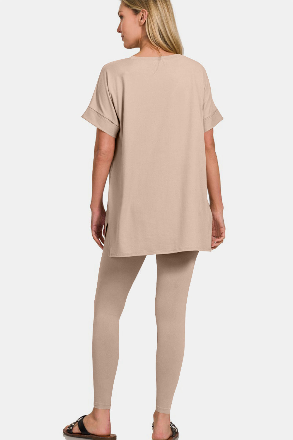 A person exudes comfort and style in the Zenana Full Size V-Neck Rolled Short Sleeve T-Shirt and Leggings Lounge Set, standing against a plain white background.