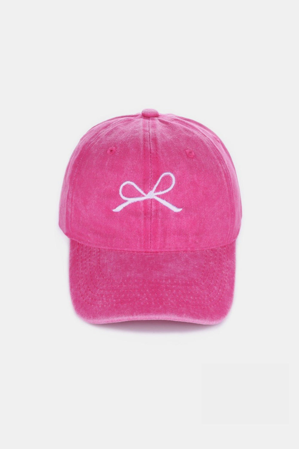 The Zenana Bow Embroidered Washed Cotton Cap features a pink design with a stylish white bow on the front, set against a plain, light background. This chic accessory seamlessly combines elegance and sportiness.