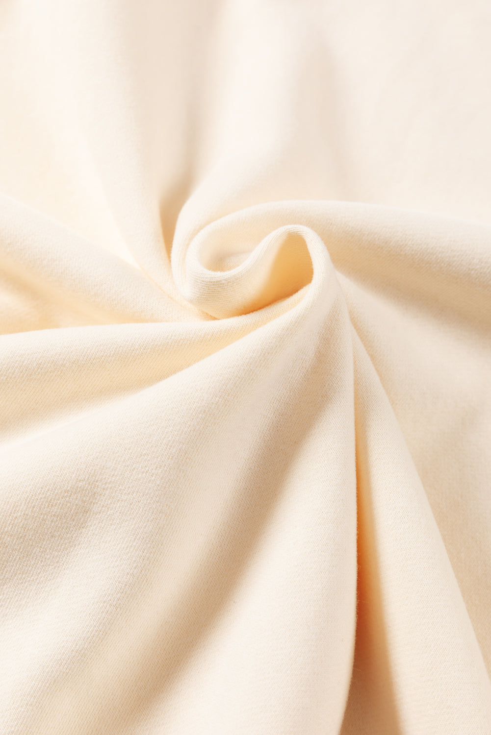 A woman with blonde hair is facing away, wearing a Contrast Stitching Split Baggy Sweatshirt. She stands in a room adorned with plants and wooden furniture in the background.