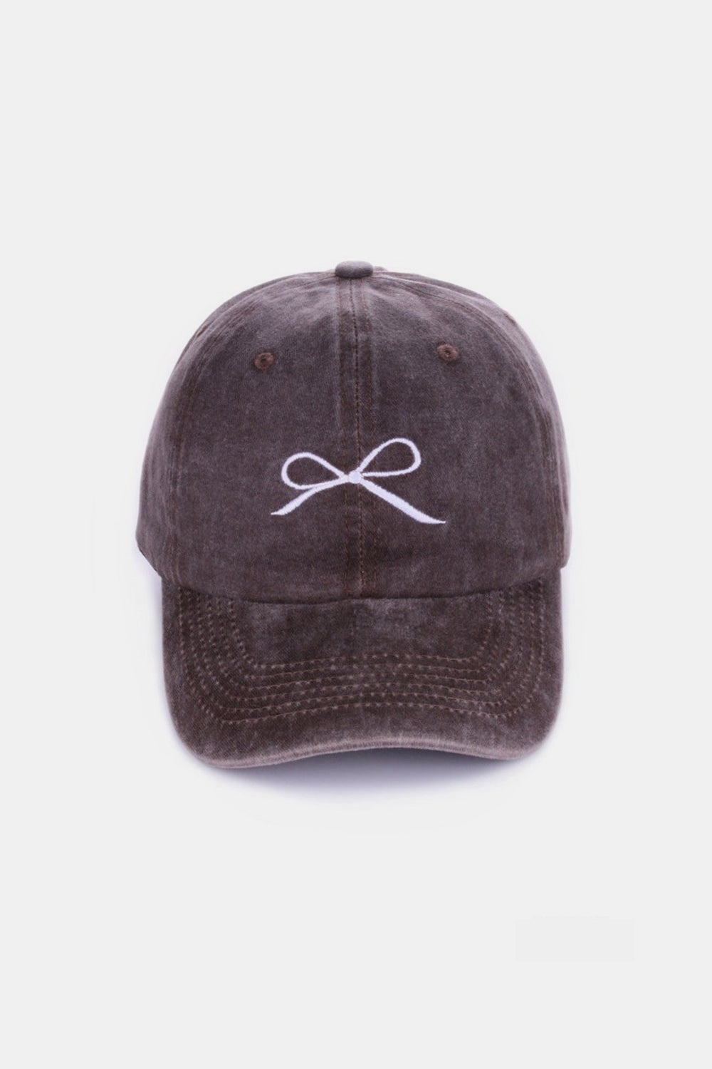 The Zenana Bow Embroidered Washed Cotton Cap features a pink design with a stylish white bow on the front, set against a plain, light background. This chic accessory seamlessly combines elegance and sportiness.