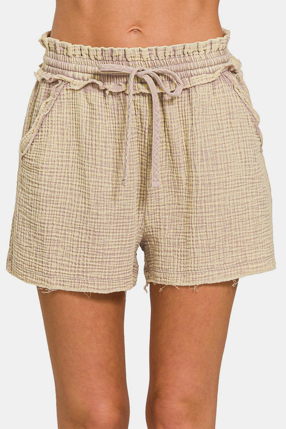 The person is wearing the Zenana Washed Frayed Hem Drawstring Shorts, featuring a light beige hue and textured cotton fabric, ideal for any summer wardrobe.