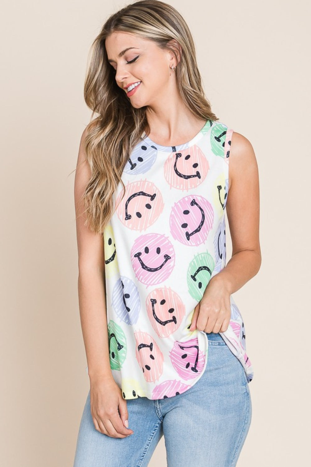 Wearing a BOMBOM Smiley Face Round Neck Tank, she poses comfortably with a warm smile in a casual and stylish outfit.