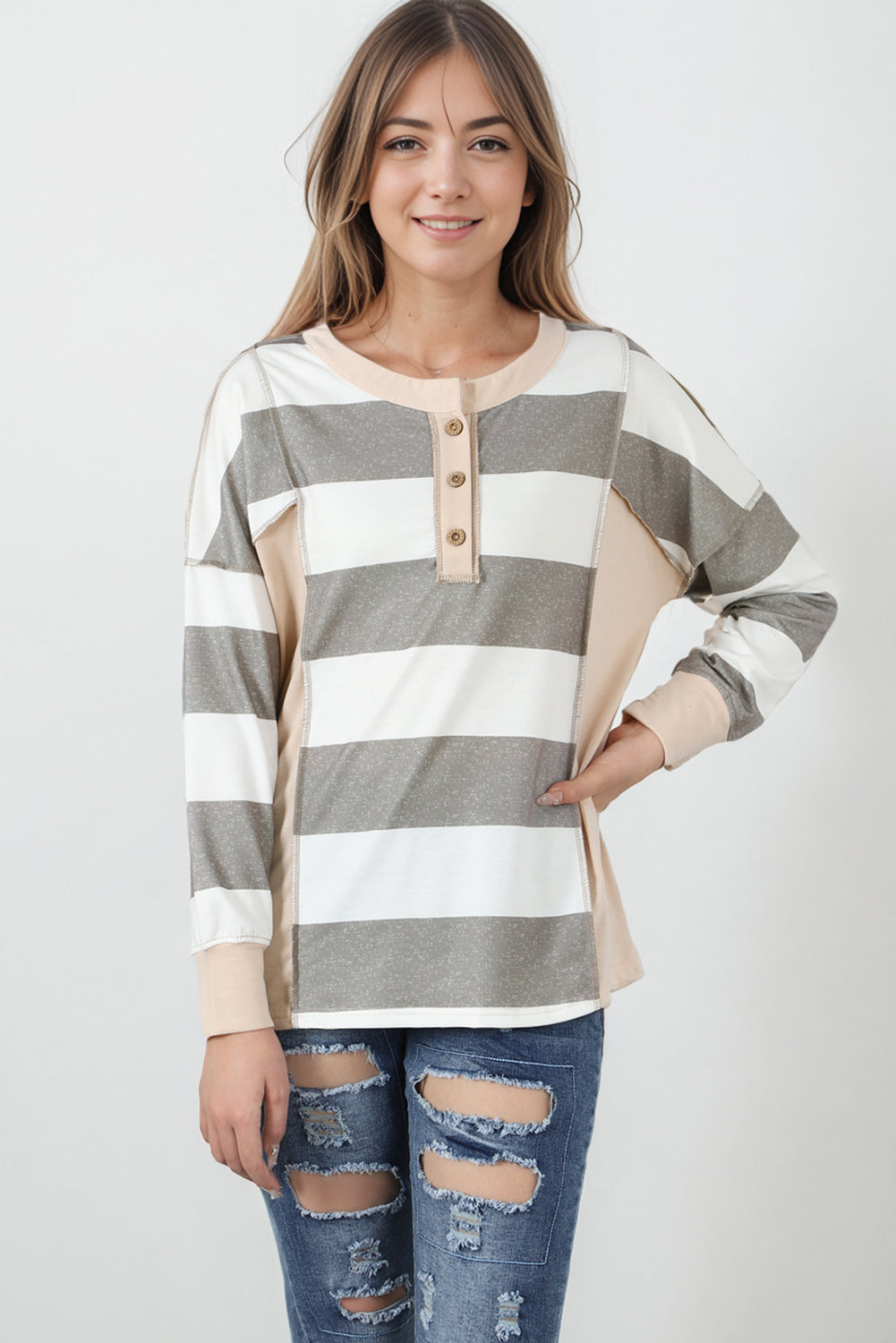 A person wearing a Multicolor Striped Colorblock Patchwork Sweatshirt paired with distressed blue jeans.