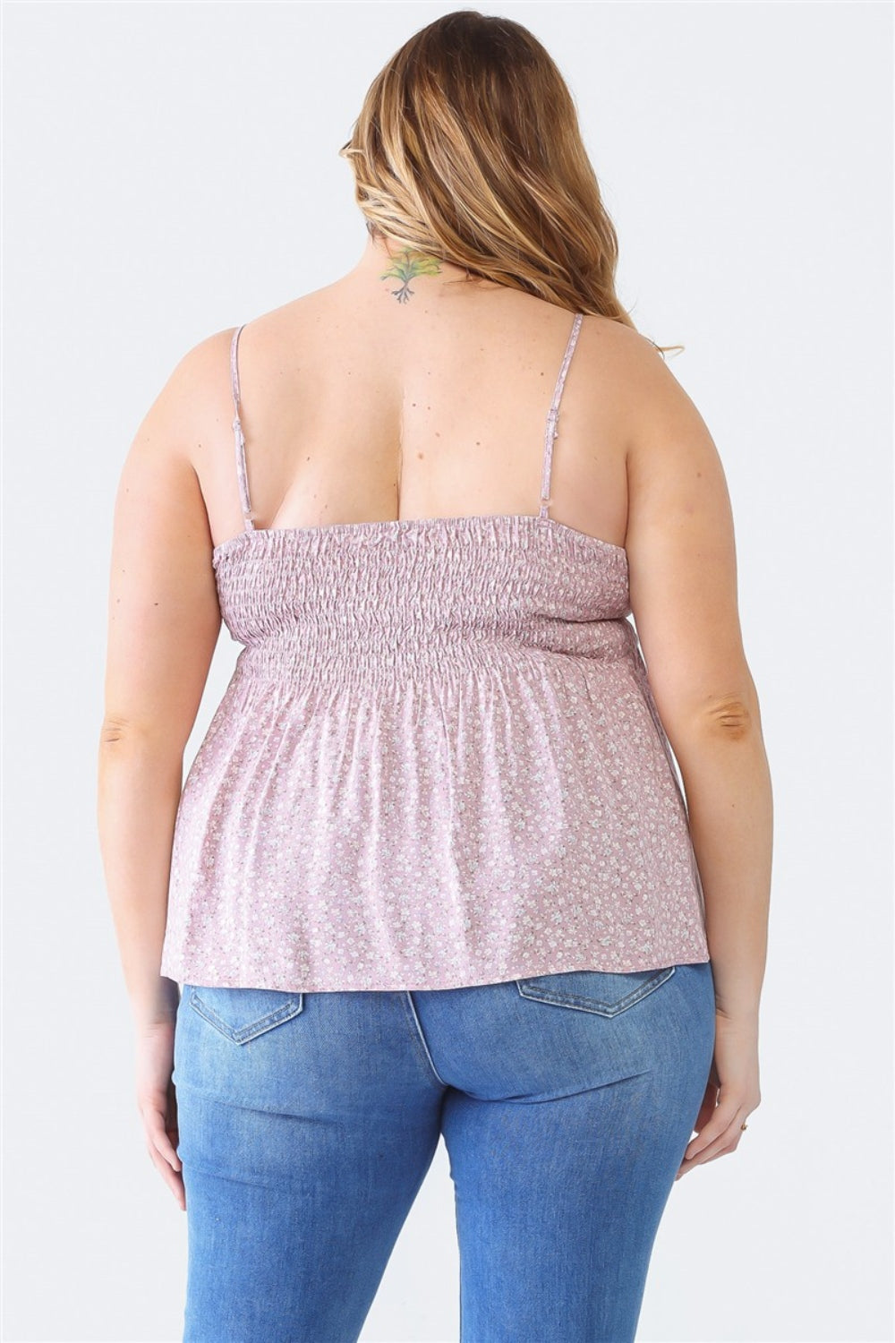 A woman stands facing the camera wearing a Zenobia Plus Size Frill Smocked Floral Sweetheart Neck Cami with dark jeans, against a plain background.