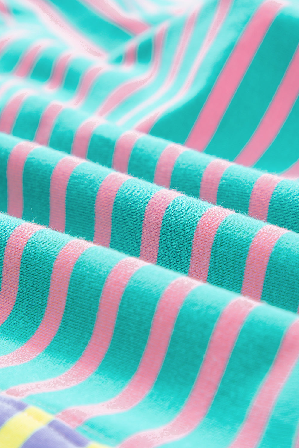 A person with wavy hair is seen from behind wearing a Casual Stripe Colorblock Drop Shoulder Oversize Sweatshirt in pastel colors and blue jeans. They are carrying a white shoulder bag, showcasing a trendy color block design.