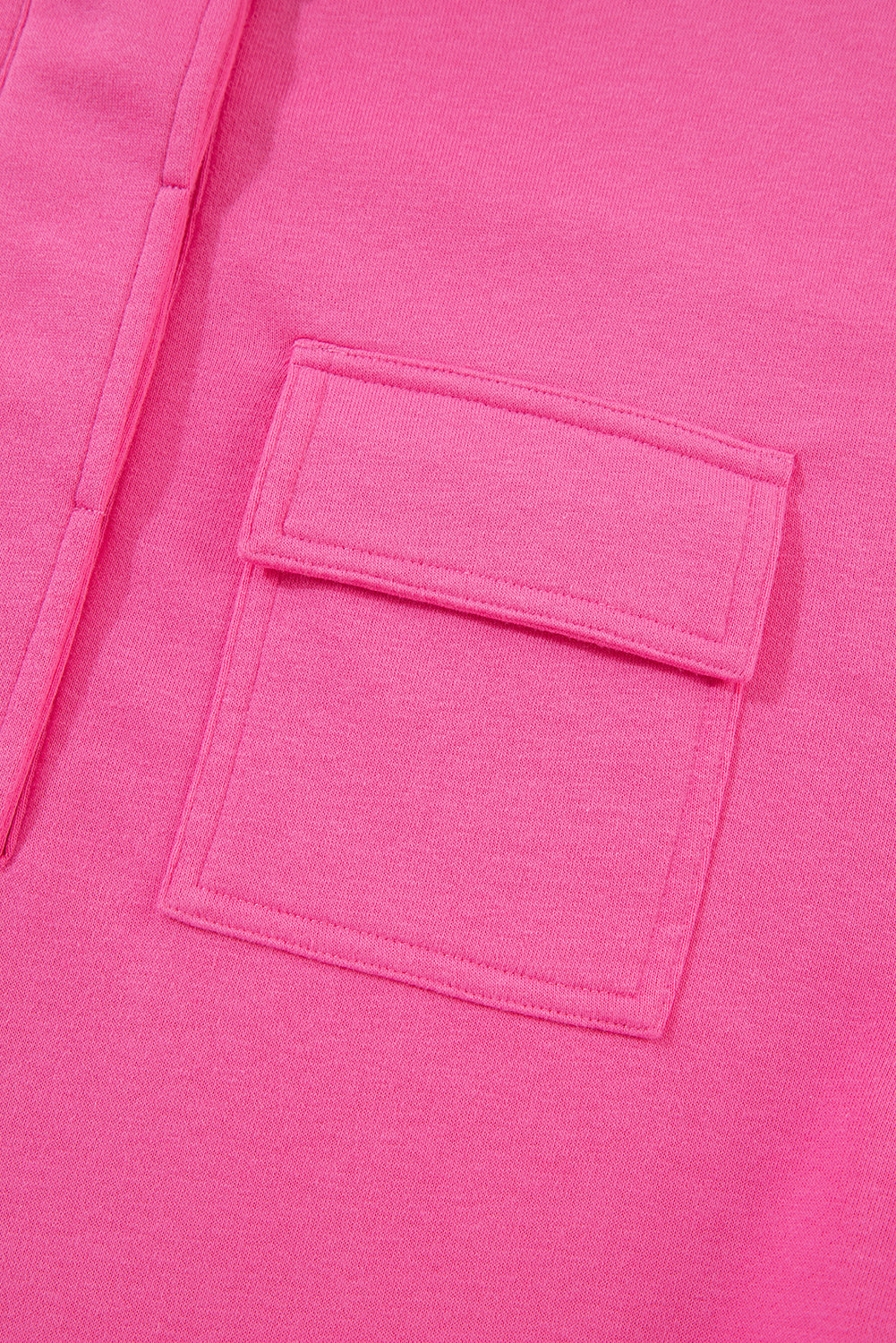 A person with long hair is seen from behind, wearing a Bright Pink Vintage Mineral Wash Half Button Collared Sweatshirt and light blue jeans.