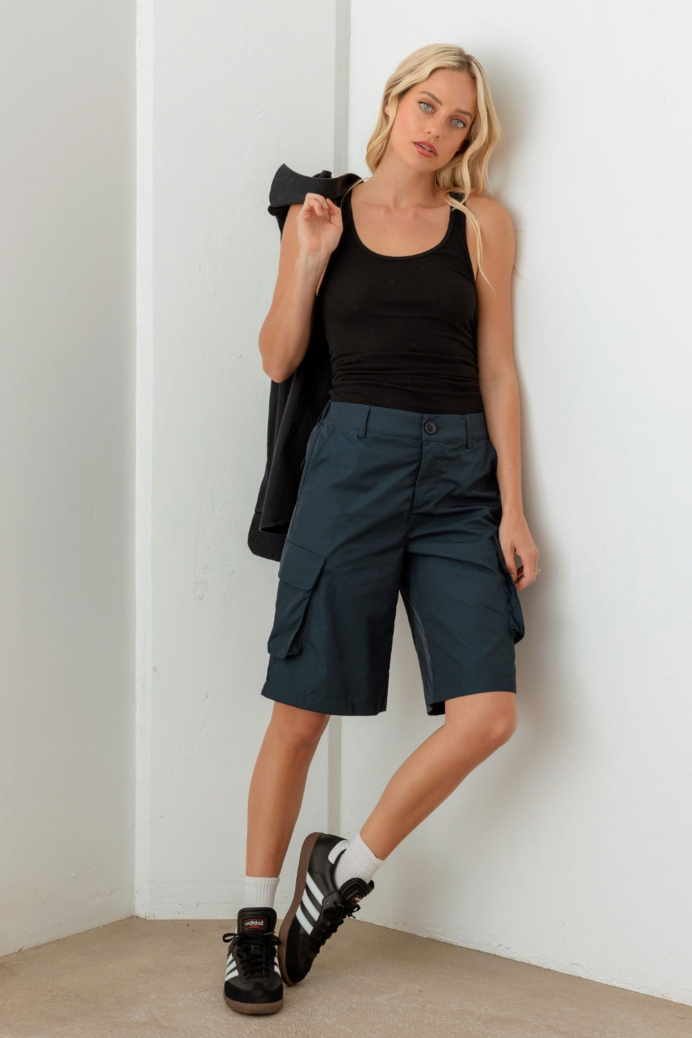 Person wearing a black sleeveless top and Le Lis Navy Cargo Bermuda Shorts with pockets, perfect for a warm-weather wardrobe.