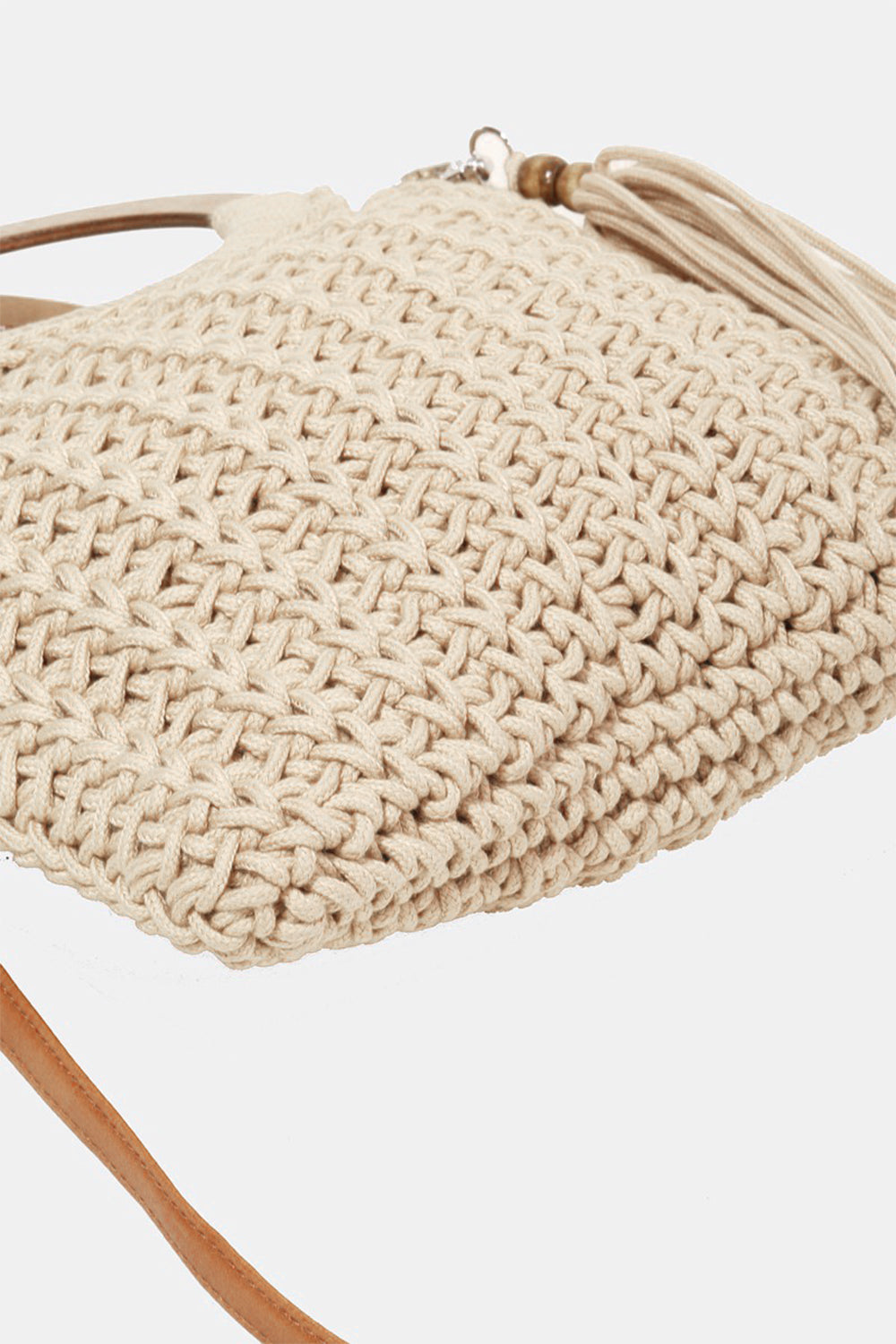 The Fame Crochet Knit Convertible Tote Bag includes a cream-colored design with round wooden handles and a matching tassel accent.