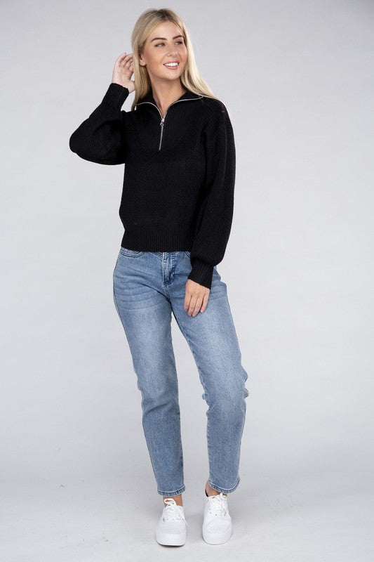 A person with long blonde hair wears a stylish cozy top—an Easy-Wear Half-Zip Pullover in grey—and blue jeans while looking down.