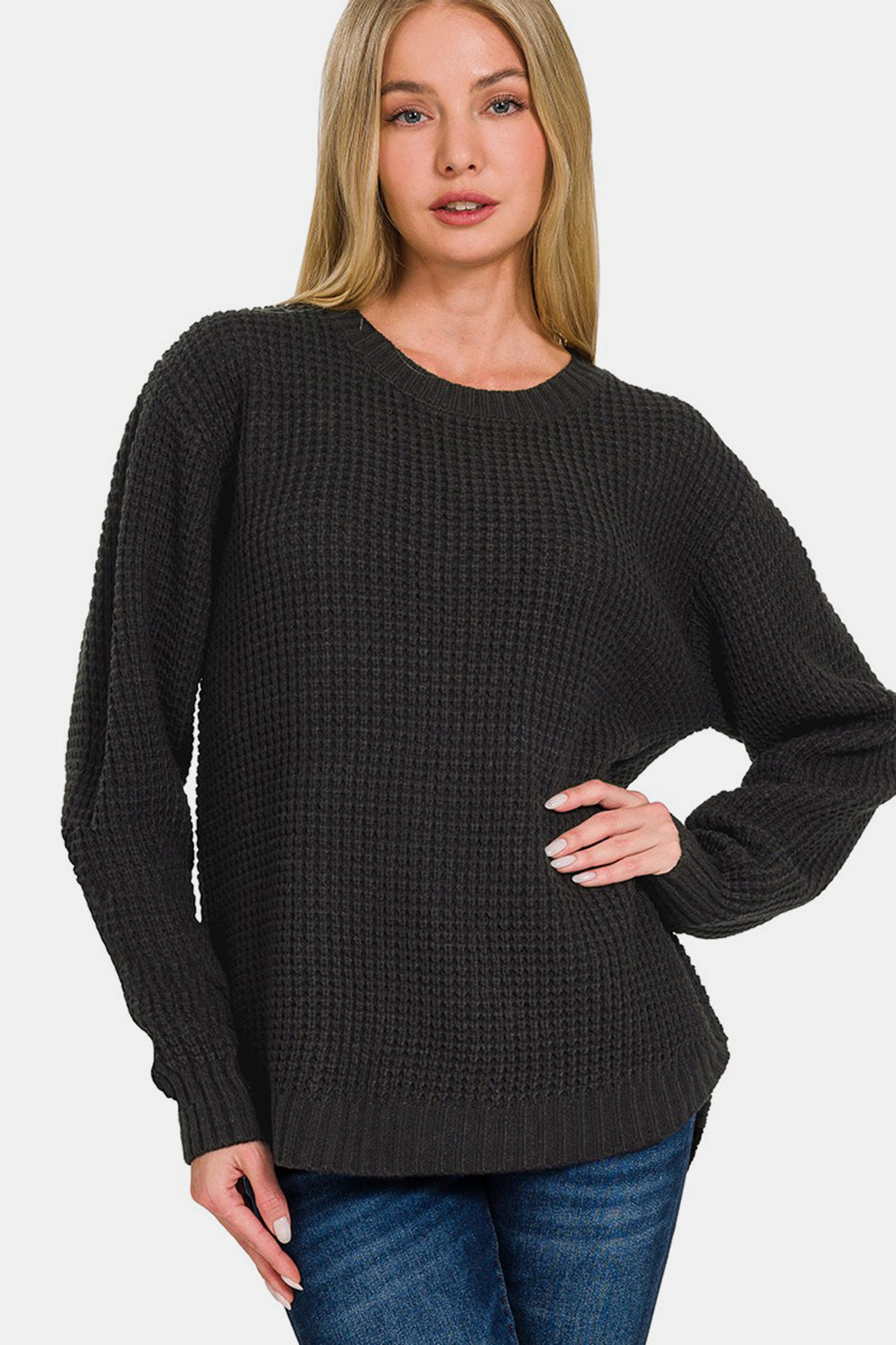 A person wearing a Zenana High Low Long Sleeve Waffle Sweater with jeans poses against a plain background.