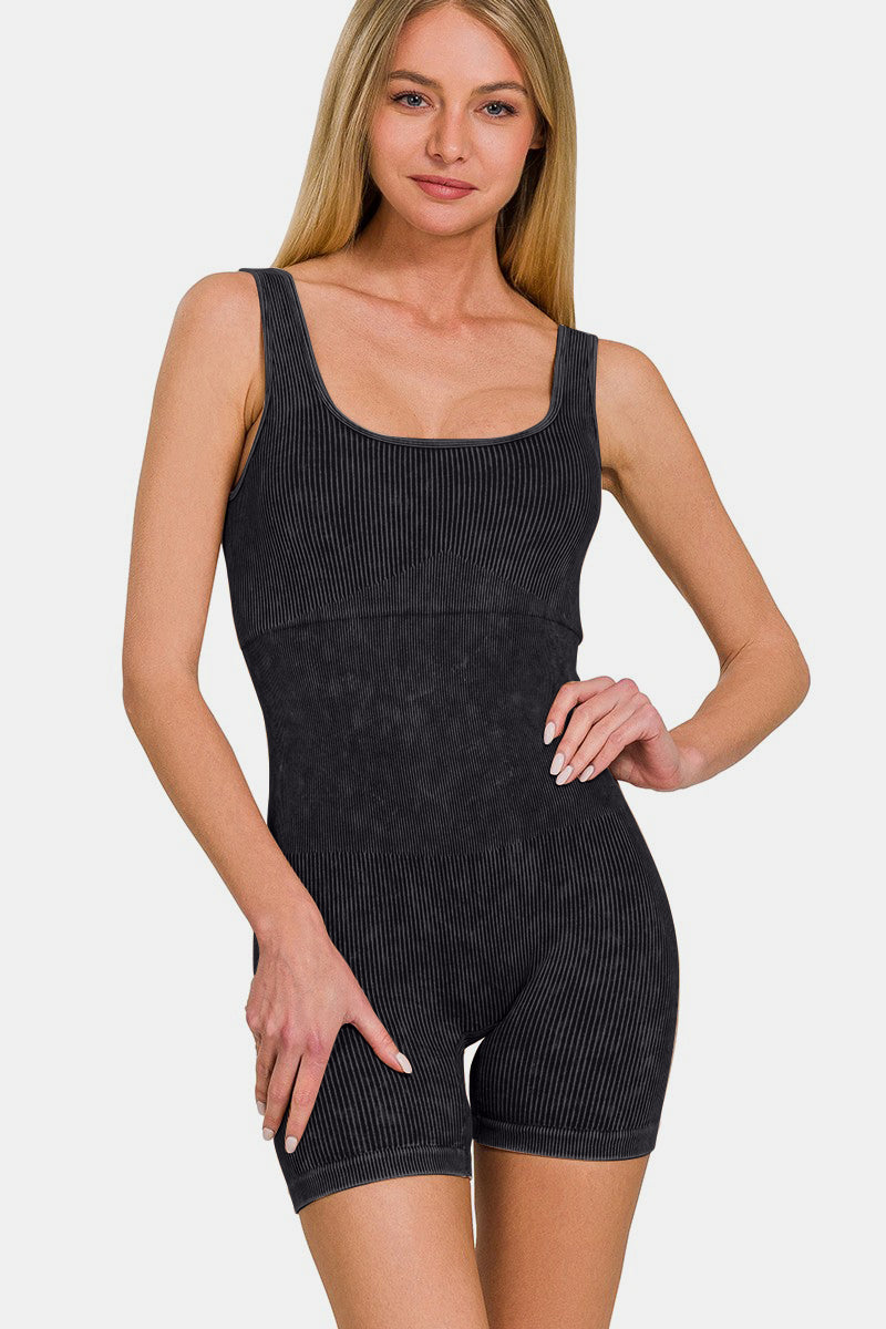 A person with long blonde hair sporting a versatile piece, the Zenana Washed Ribbed Romper with Pad, stands with one hand on their hip against a plain background.