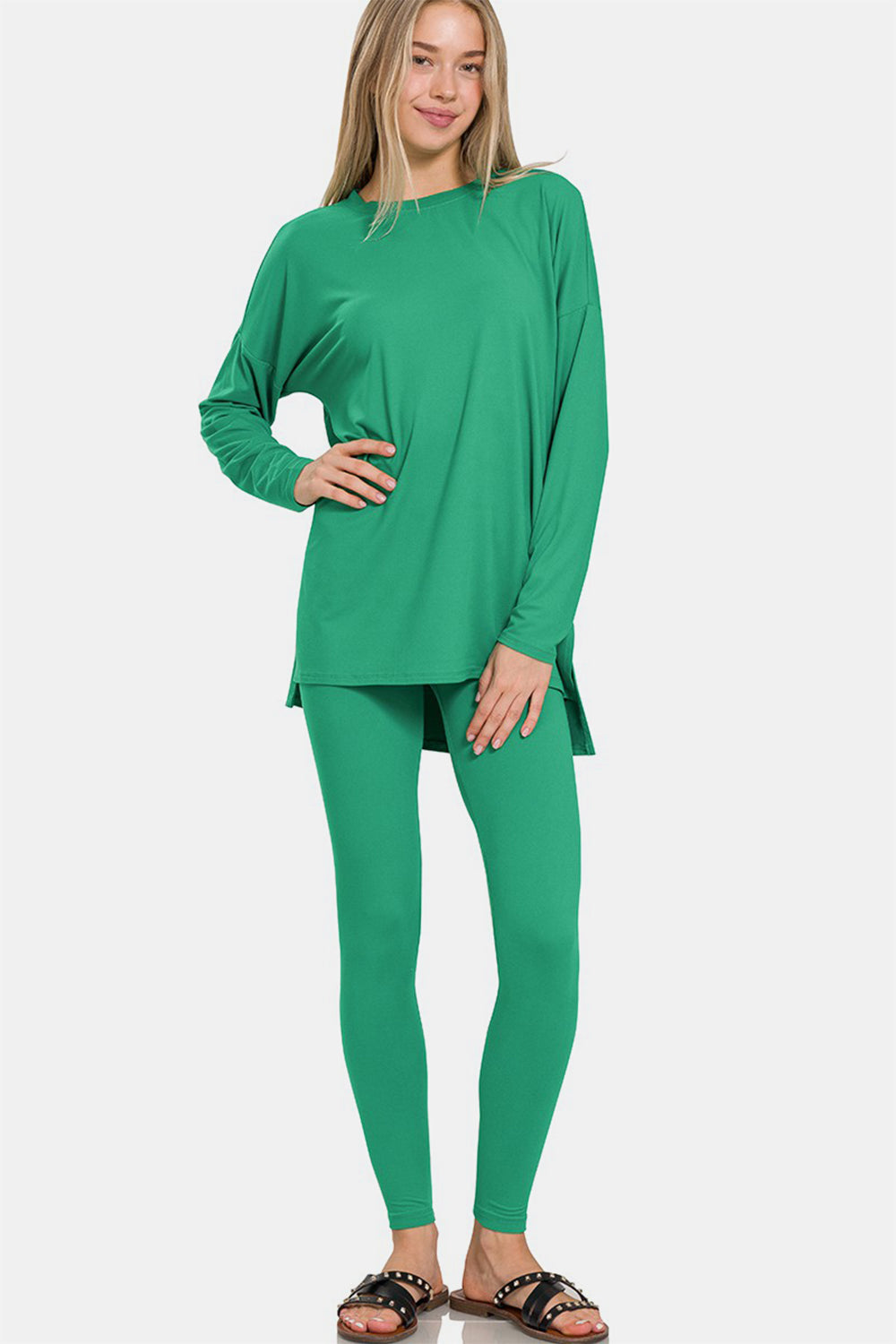 A person wearing the Zenana Full Size Brushed Microfiber Top and Leggings Lounge Set in bright green stands with one hand on their hip.