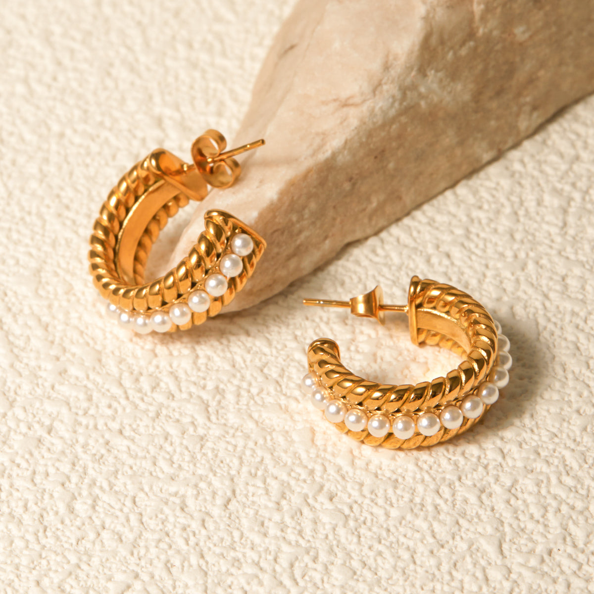 Close-up of a person's ear wearing Stainless Steel Pearl C-Hoop Earrings featuring a row of small synthetic pearls.