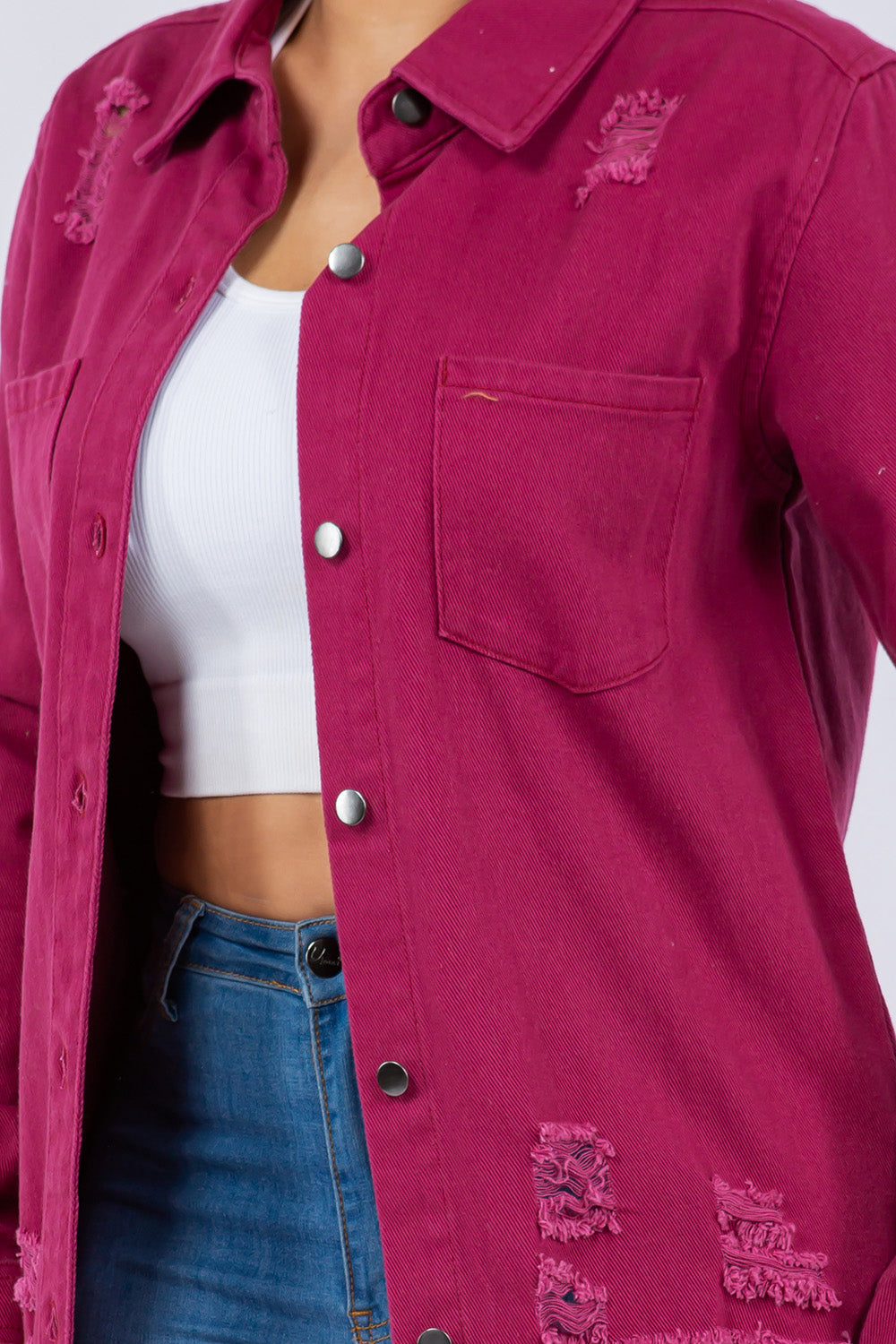 Person wearing an American Bazi Distressed Button-Up Long Sleeve Denim Jacket in pink over a white crop top and blue jeans, posing against a plain background.