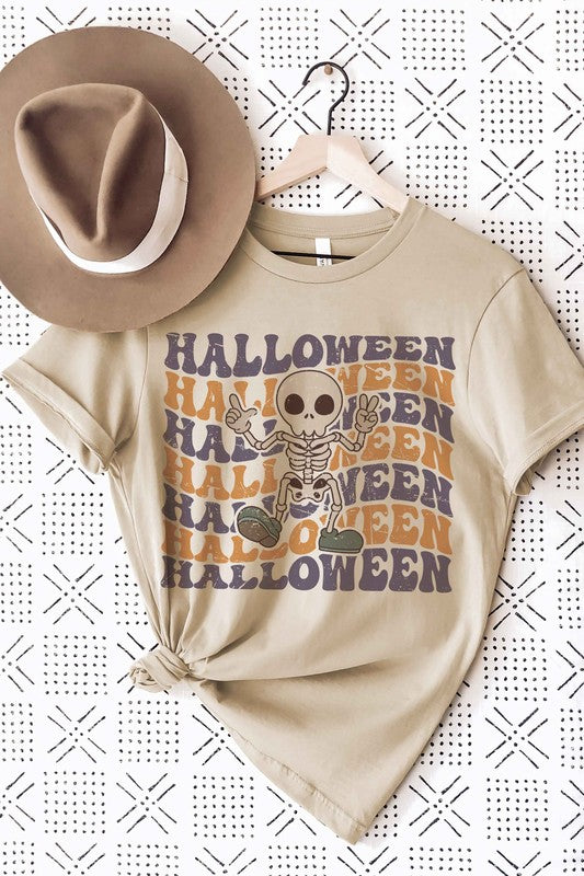 Person wearing the HALLOWEEN SKELETON Graphic Tee, which features a cartoon Halloween skeleton and the word "HALLOWEEN" repeated in orange and purple text.