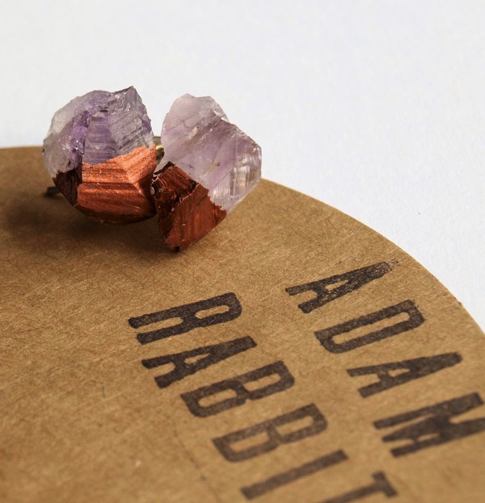 Introducing the Bronze & Raw Amethyst Chunk Earrings, uniquely designed to showcase the captivating raw crystal allure in purple and copper tones. These geo and rock stud earrings are elegantly set against a larger crystal backdrop and crafted with surgical steel posts for enhanced comfort and durability.