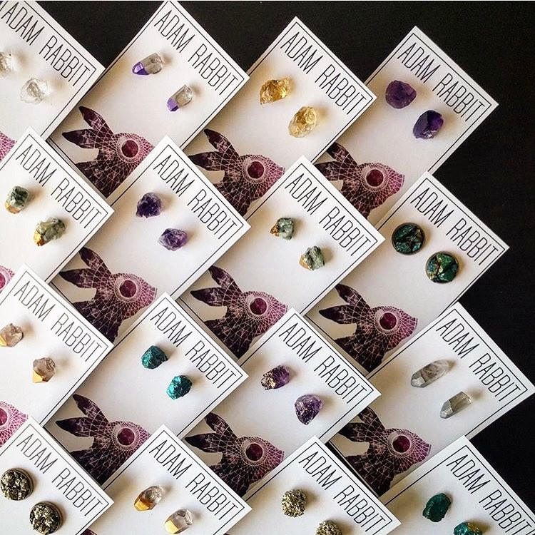 The Peacock Ore Cluster Stud Earrings, with their raw peacock ore accents, evoke the charm of bronze earrings as they rest on a dark backdrop, making them ideal for gift giving.