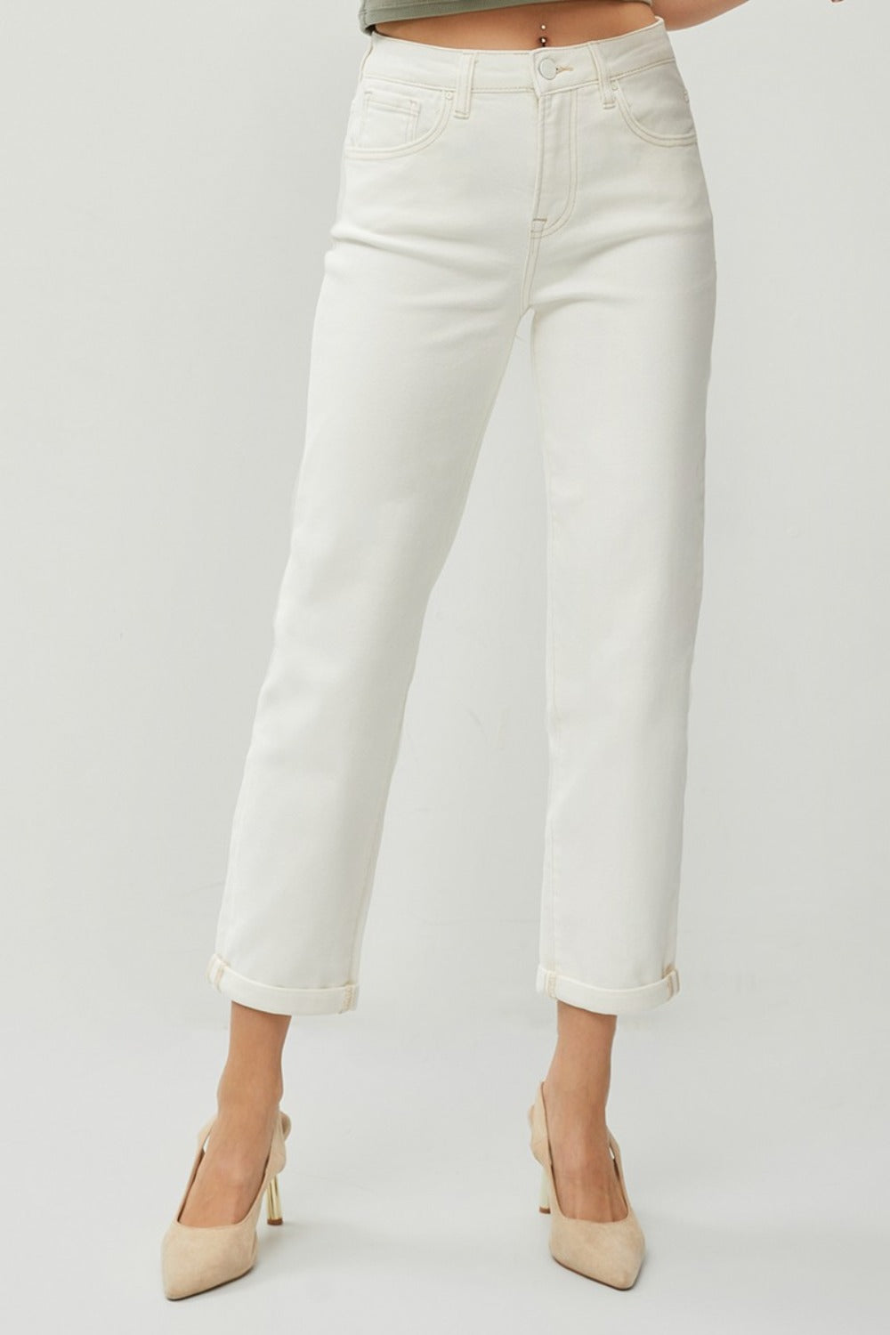 Description: Person wearing RISEN Full Size High Waist Rolled Hem Straight Jeans in white with beige heels against a plain background. 