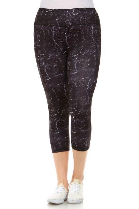 A person wearing Copy of PLUS Black Marble Print Capri Leggings and white sneakers stands with one leg slightly crossed over the other.